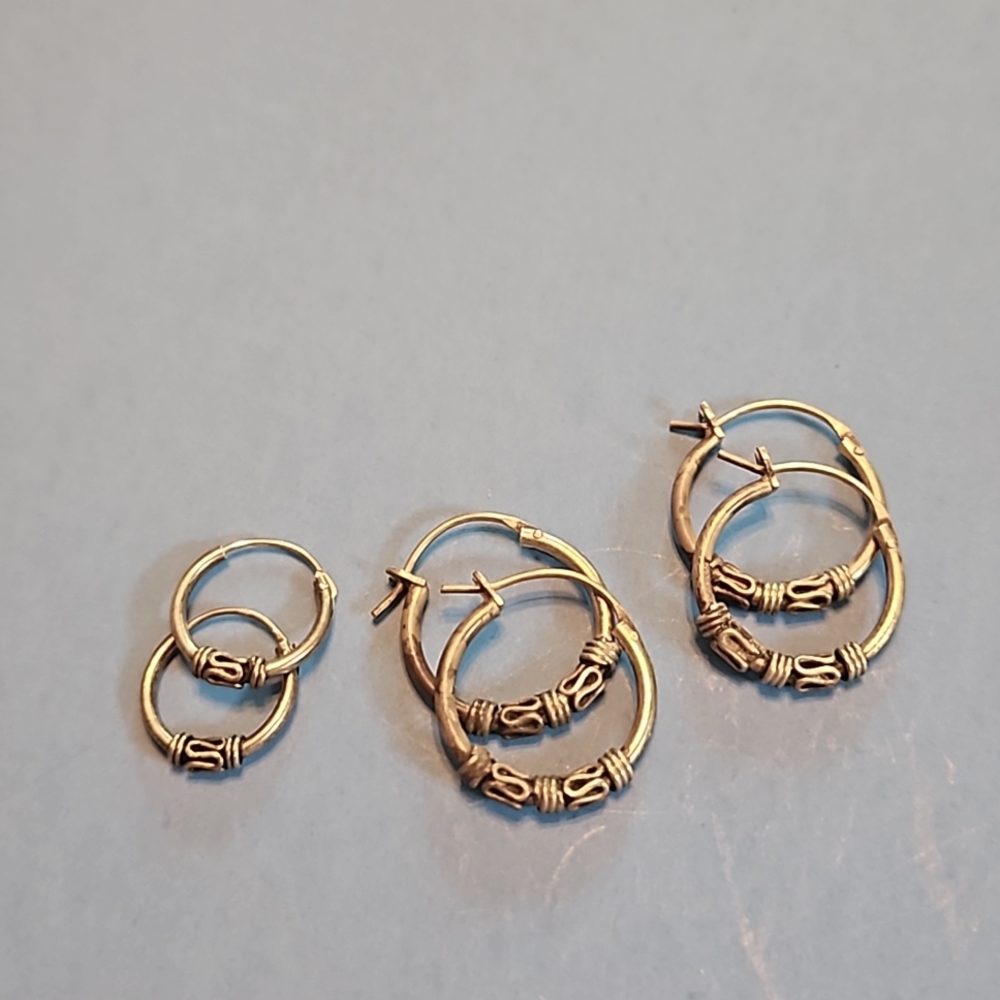 Three pairs of intricate silver earrings